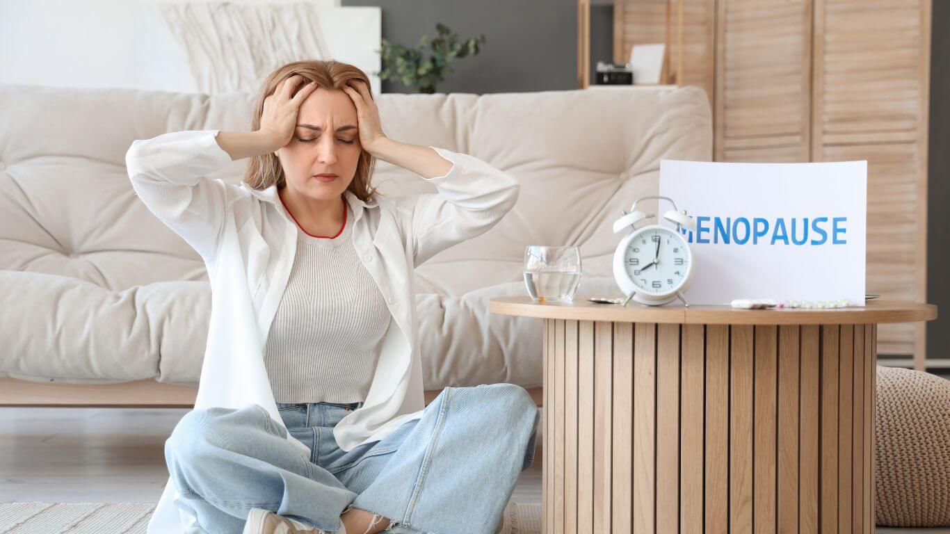 Woman holding head with hot flushes, an early menopause symptom